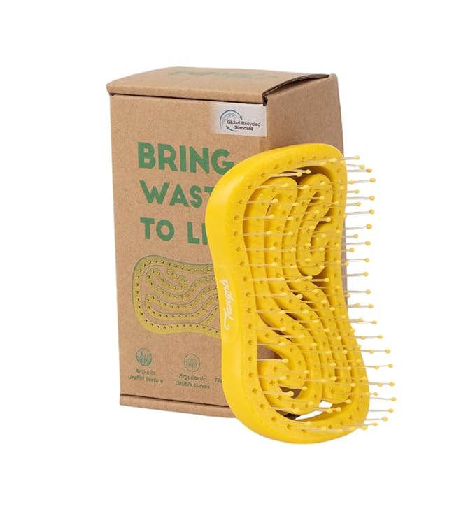 Yellow hairbrush in eco-friendly packaging with sustainability message