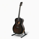 Acoustic guitar on stand against a white backdrop