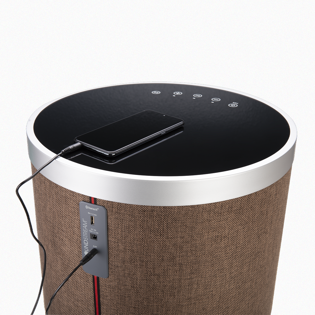 Back view of brown Soundstream speaker table charging a smartphone